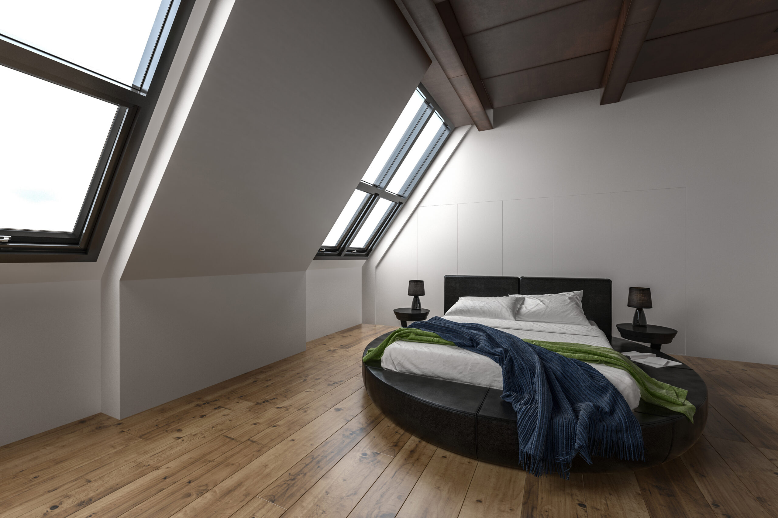 A modern attic bedroom with large slanted windows, a round black bed, white bedding, blue and green throws, two black bedside tables, and wooden floors. Natural light fills the minimalist space.